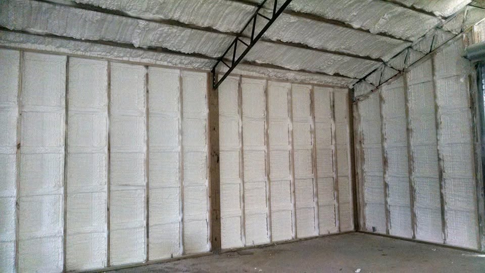 Closed-cell spray foam insulation across the interior walls and ceiling of a Your City building